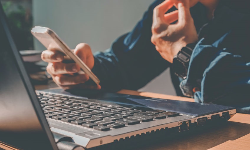 Man's using laptop with blank screen on desk in home interior. B