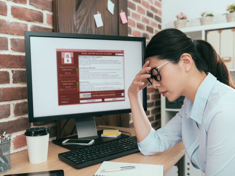 tristeza, agente de la empresa, mujer que encuentra una computadora que trabaja y que está chantajeando. El ataque contra el virus piensa en una solución en el escritorio de la oficina y siente depresión.